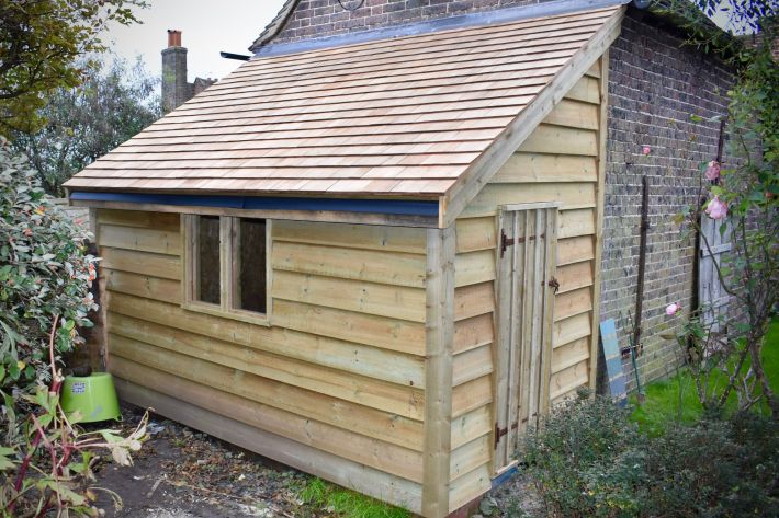 Lean-to garden building with cedar shingle roof
