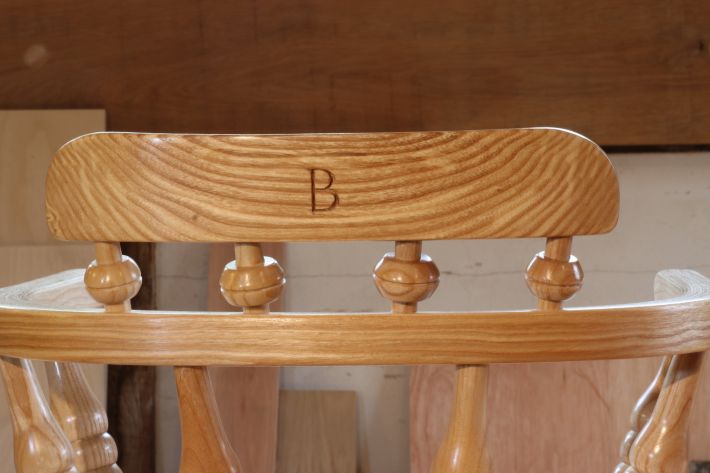 Carving of initial on a child's chair